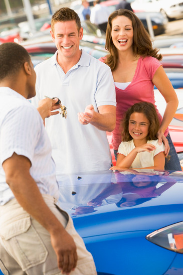 Man handing car keys over to family.